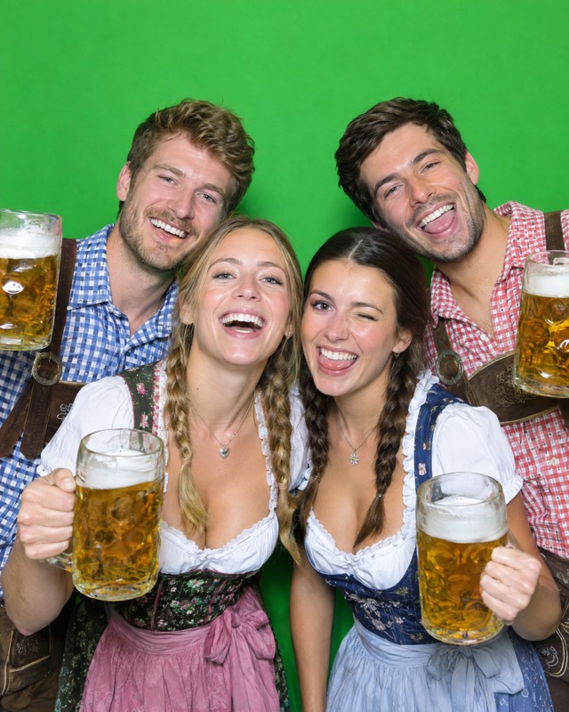Greenscreen vorher: Gruppe in Tracht vor grünem Hintergrund